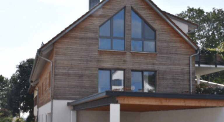 Wohnhaus mit Holzfassade und grossen Fensterflaechen