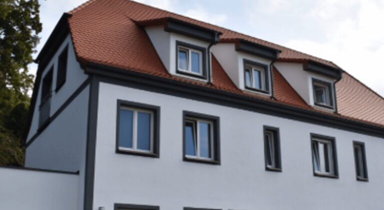 Saniertes Stadthaus mit Gauben und hellem Putz